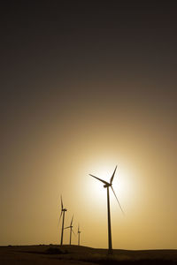 Windmills for electric power production at sunrise.