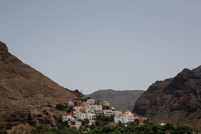 Town by mountains against clear sky