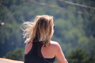 Rear view of woman sitting outdoors 