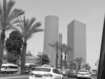 Cars on city street against clear sky