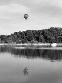 Hot air balloon in lake against sky