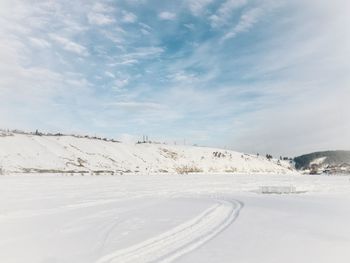 Scenic view of snow covered land against sky