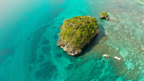 Clear turquoise water in a lagoon with rocky islands and corall reef from above boracay, philippines