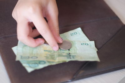 Cropped hand of person touching currency