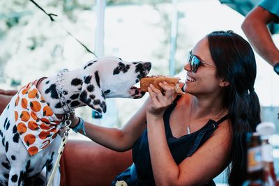 Smiling woman feeding dog