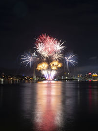 Illuminated city at night with firework display