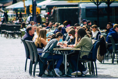 People sitting on table at cafe in city