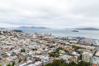 High angle view of townscape by sea against sky