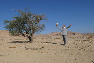 Senior man standing on sand in the desert 