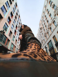 Low angle view of woman in city against sky