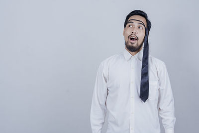 Young man looking away against white background