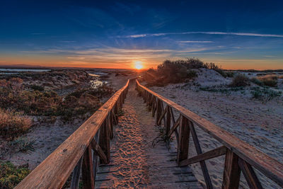 Scenic view of snow covered landscape against sky during sunset