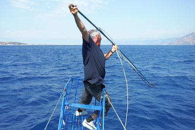 Low angle view of person on sea against sky