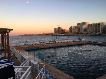 View of city at waterfront during sunset