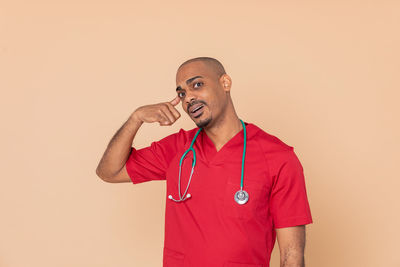 Portrait of young man standing against white background