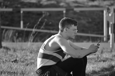 Man using mobile phone on field