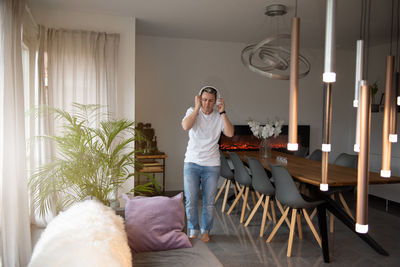 Side view of young woman using mobile phone while sitting at home