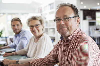 Portrait of two generation family sitting at dining table