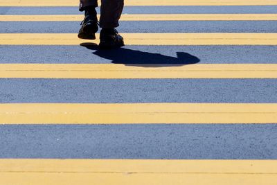 Low section of man walking on road