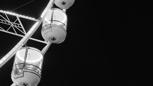 Low angle view of carousel against clear sky at night