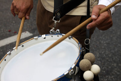 Midsection of man playing drum at music concert