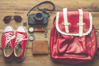 High angle view of red bag with accessories on table