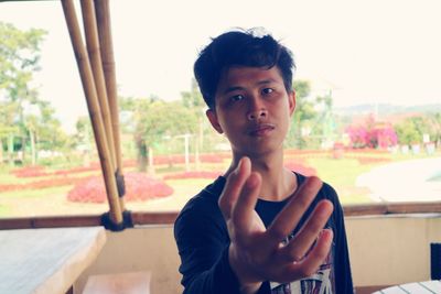 Portrait of young man gesturing in restaurant