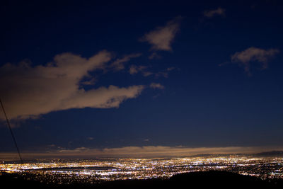 Illuminated cityscape against sky at night