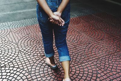 Low section of woman standing on footpath