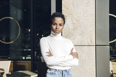 Young woman standing against window