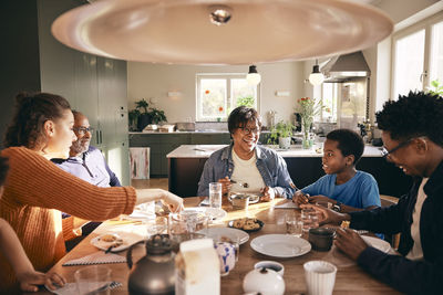 Multiracial family enjoying having food with each other at home