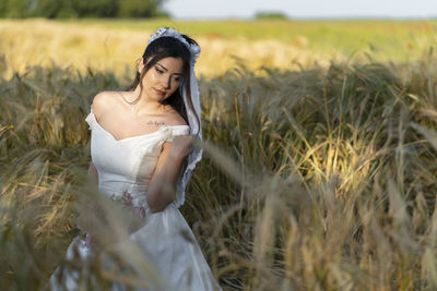 Portrait of young woman sitting on field
