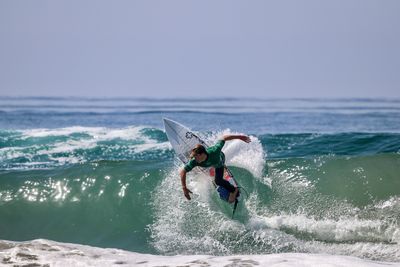 Man surfing in sea against sky