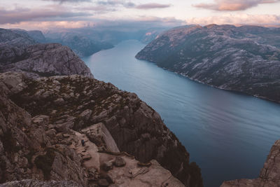 Scenic view of norwegian fjords, blue sky, unrecognizable couple standing in the rocks