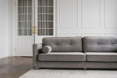 Gray modern sofa in the interior of a cozy living room