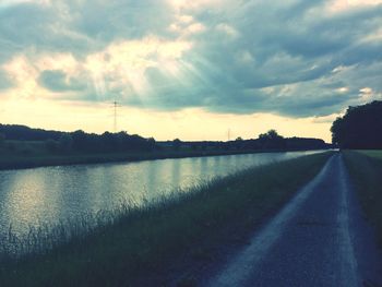 Scenic view of river against cloudy sky