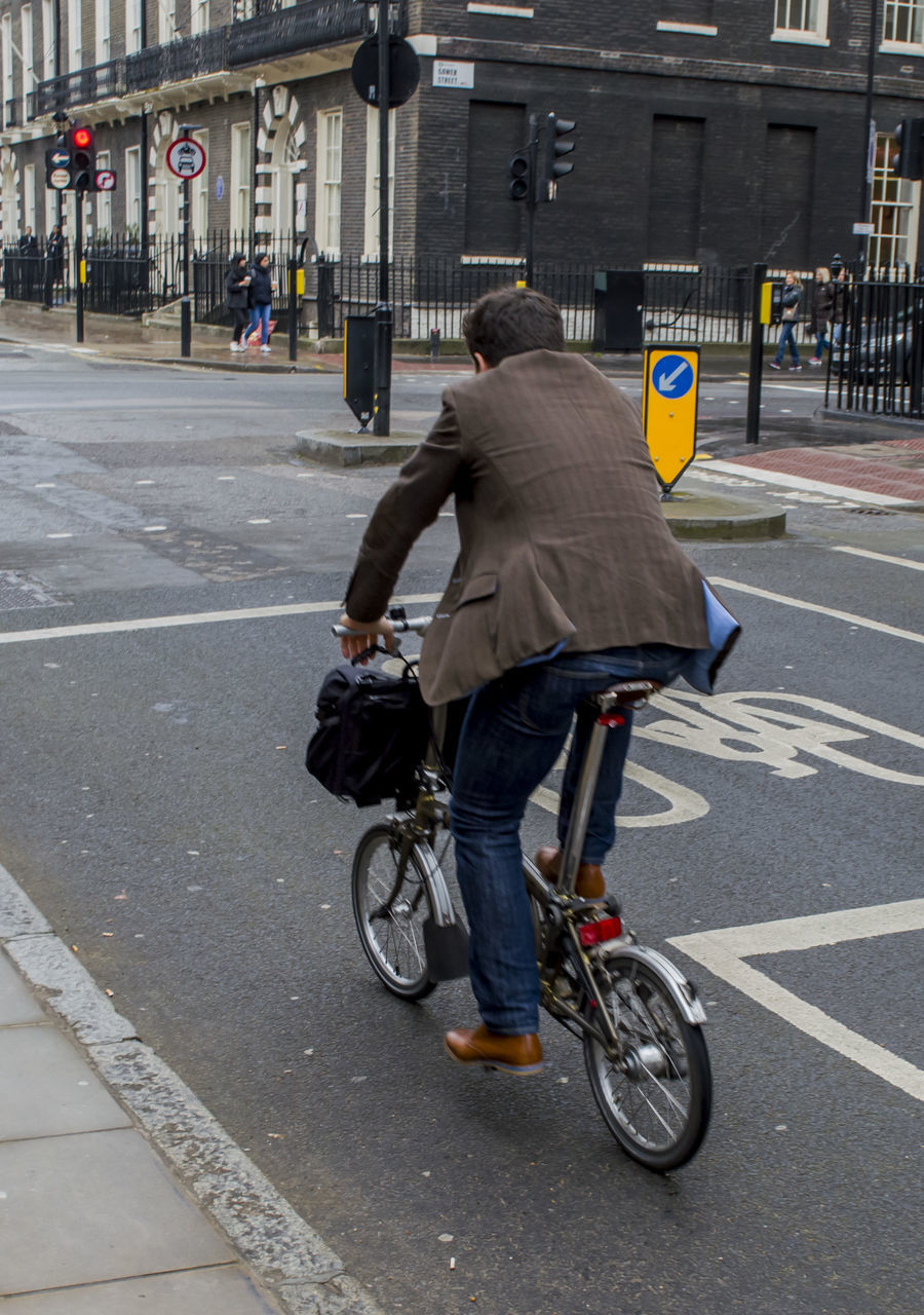 MAN WITH BICYCLE ON STREET