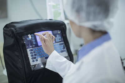 Woman typing on display of a machine