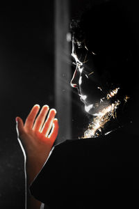 Close-up of woman hand against black background