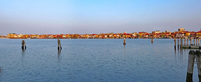 Panoramic view of wooden posts in sea against clear sky