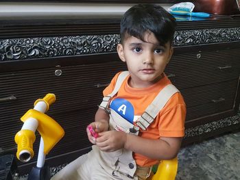 Portrait of boy sitting at toy