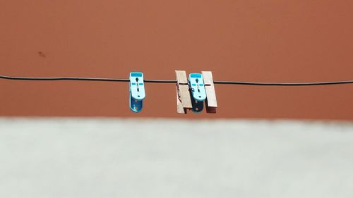 Clothespins on clothesline against orange background