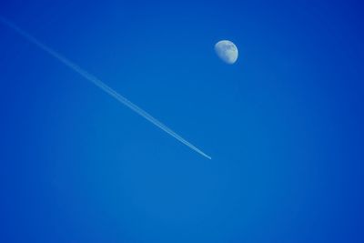 Low angle view of moon against blue sky