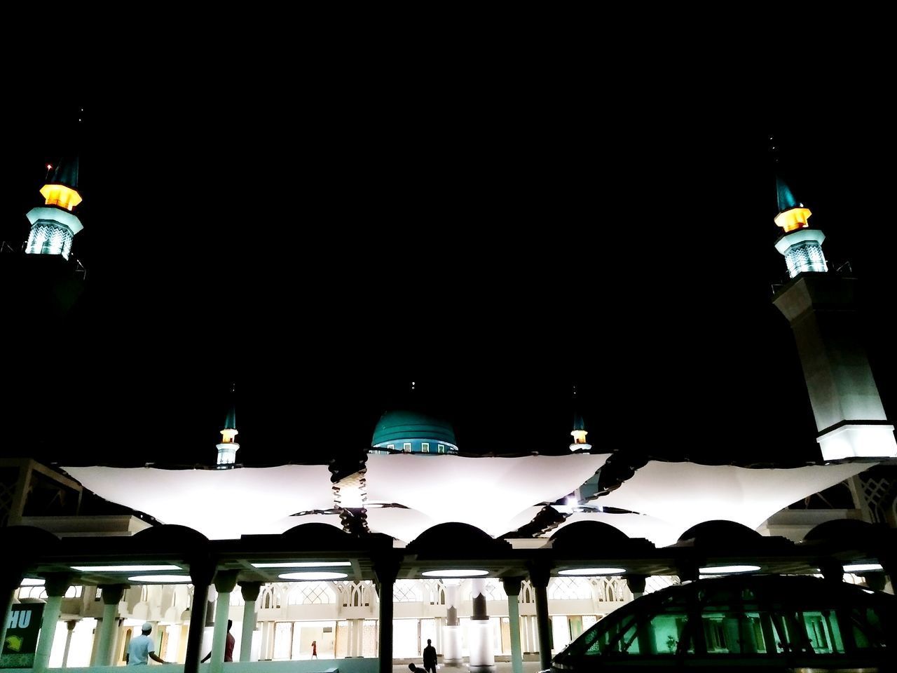 LOW ANGLE VIEW OF ILLUMINATED BUILDING AT NIGHT