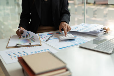 Midsection of business colleagues working on table