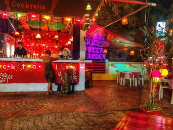 People standing on illuminated street at night