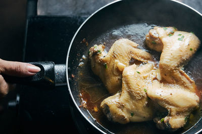 Close-up of woman preparing food in cooking pan