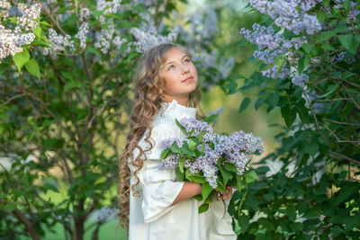 Woman standing by flowering plants