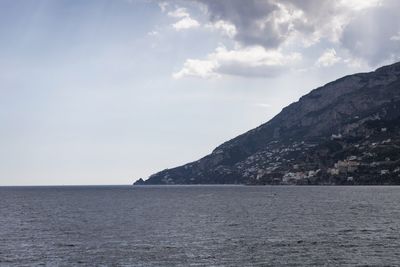 Scenic view of sea and mountains against sky