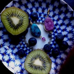 High angle view of kiwis and blueberries with earrings